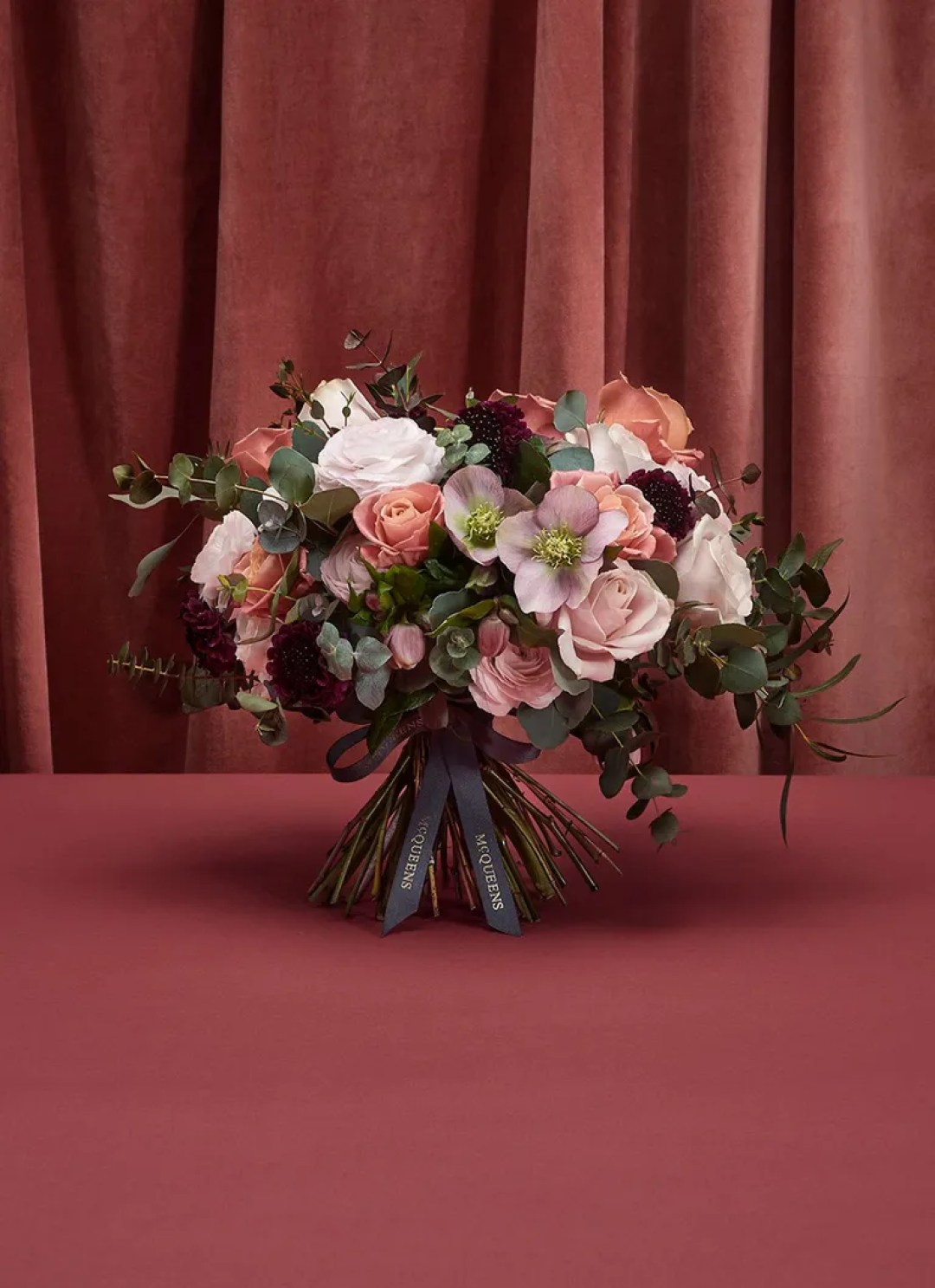 McQueen’s flowers of London, Seoul, and New York bouquet of pink and white flowers and green stems against pink background 